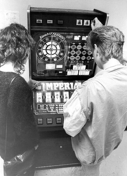 Young people playing on a one armed bandit or electronic gaming machine in September 1983