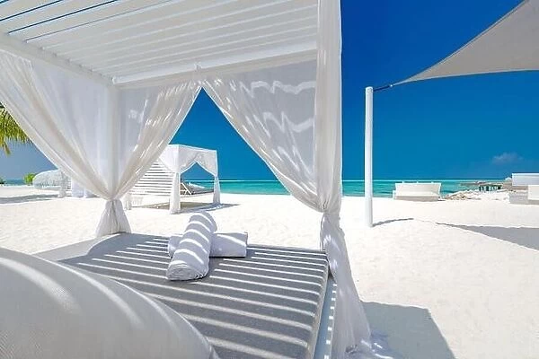 Amazing tropical beach scene with white canopy and curtain for luxury summer relaxation concept. Blue sky with white sand for sunny beach landscape