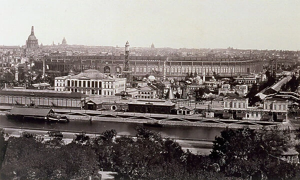 In the background, beyond the seine, the expo palace and a few pavilions of the fair in Paris. In the foreground, dense foliage of trees in a garden