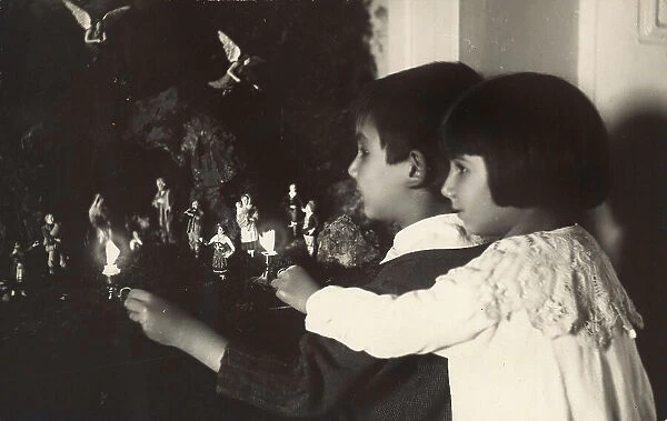 Two children before a nativity crche