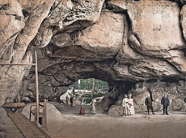 A group of people walking in a tunnel hollowed out in the rocks, in Sachs, Germany