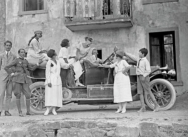 Group of young people posing next to a car