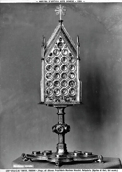 Mounted relic, decorated with circles, topped with a radiant cross; the object is attributed to Ugolino di Vieri, it was on display in the Exhibition of Antique Siennese Art. The reliquary was at the time property of the Marquis Niccolini, near Frosini, environs of Chiusdino, province of Siena