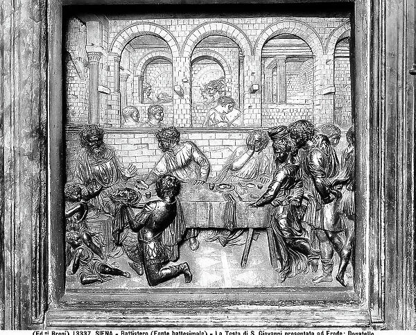 Panel representing the moment when the head of St. John the Baptist is offered to Herod. Sculpted work by Donatello, belonging to the Baptismal Font of the Baptistery of Siena