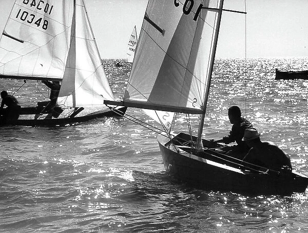 Photograph showing some small sailboats during a regatta