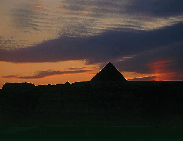 The pyramids of Giza in the distance, even against the sunset
