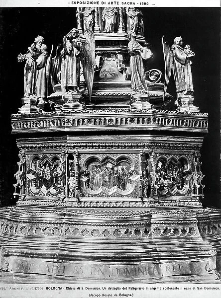Detail of the reliquary of the head of St. Dominic, work by Jacopo Roseto, located in the church of the same name, Bologna. The image shows the misitlinear base on a downward slope with inscription. The structure is decorated with some small polybate and historiated forms. On the top is a long line of angel musicians