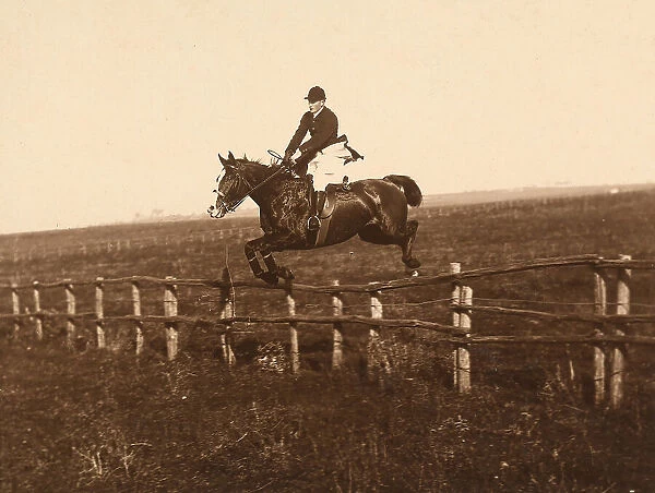 Rider on horseback photographed while jumping a fence at San Cesareo, near Rome