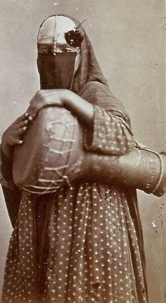 A souvenir of Odoardo Beccari's journeys: portrait of an Egyptian woman wearing a chador and holding a drum