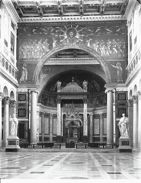 View of the central nave of the Basilica of S. Paolo Fuori Le Mura in Rome. In the background is visible the majestic triumphal arch and above the high altar the gothic ciborium by Arnolfo di Cambio
