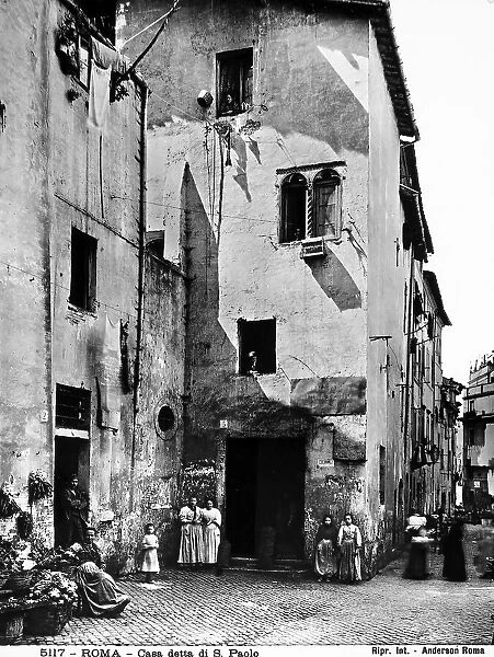 View of the so-called house of St. Paul, Rome. In the small piazza below, some people are posing for a photograph
