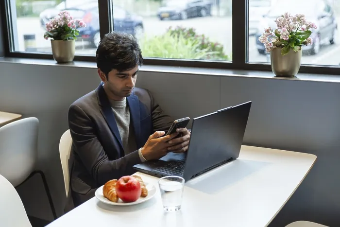 Framed Print : Indian Man Multitasking with Smartphone and Laptop Print