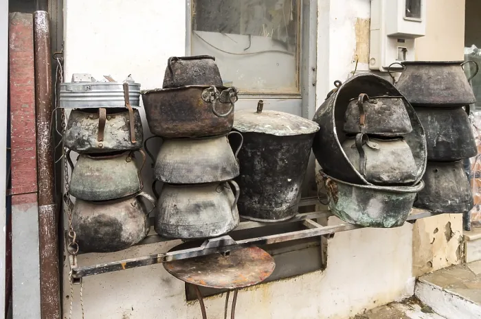 Framed Print : Several old cauldrons in heap in front of a facade Print