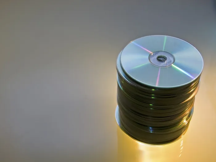 Framed Print : Pile of CDs and DVDs on a Print Surface Framed Print : Pile of CDs and DVDs on a Print Surface