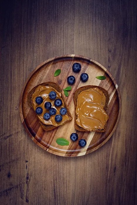 Framed Print : Rye bread with peanut paste and blueberries print, top view