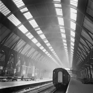 Print of Kings Cross Station interior, showing a train on an empty platform Print of Kings Cross Station interior, showing a train on an empty platform