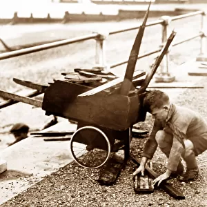 Boy collecting driftwood at seaside, 1930s