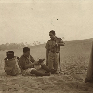 Boy scouts sitting by tent in desert, Egypt
