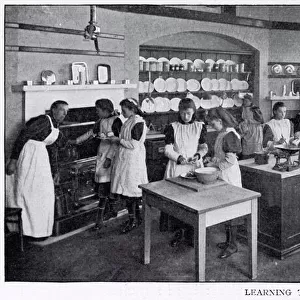 Girls in a cookery lesson, learning to cook tarts and a joint of beef which a group of