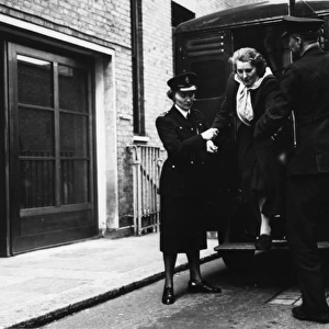Helping woman out of the back of a police van, London