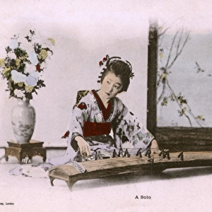 Japan - Woman in a kimono playing a traditional Koto