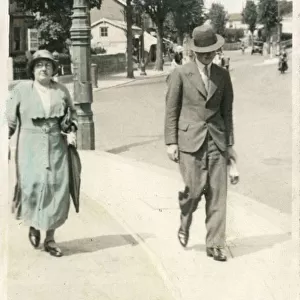 Mother and adult son stroll along a Worthing pavement