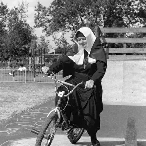 Nun on a bicycle in a playground