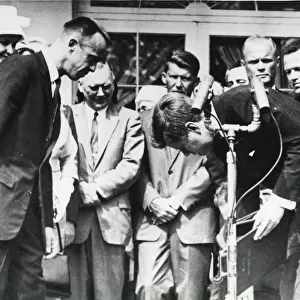 President John F. Kennedy stoops to retrieve the Nation?