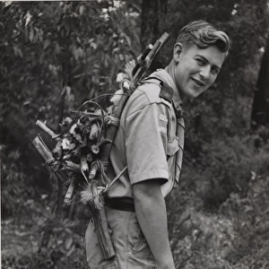 Scout carrying wood on his back in Australia