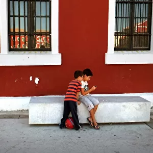 Two small boys look in the Placa des Esplanada, Es Castell