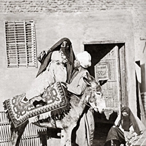 Veiled woman mounting a donkey, Egypt, circa 1880s