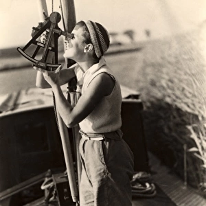 Woman looks through sextant on board a boat