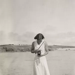 Woman taking a photograph on the beach