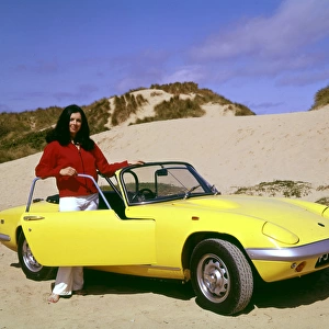Woman with yellow sports car on a beach