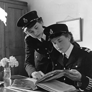 Two women police officers working in a station, London