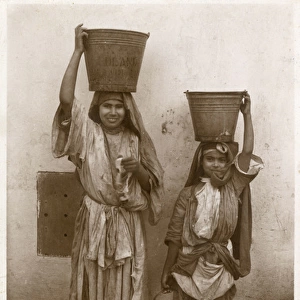 Two young Moroccan Girls with buckets on their heads