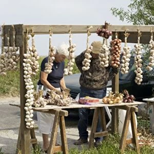 Buying garlic and onions roadside stall Brittany France