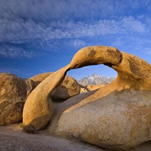 Mobius Arch - Lone Pine, one of the snow-capped mountains of the Sierra Nevada, seen through rock arch of red granite. In early morning - Alabama Hills Recreation Area, California, USA