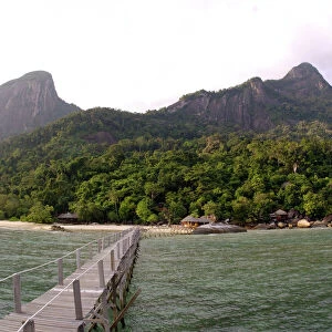 Rainforest, volcanic "Twin Peaks" - Bukit Batu Sirau and Bukit Semukut peaks, and the Gunung Kajang peak on the left, a jetty and a wooden cabins of the "Bagus Place Retreat" - a small private resort