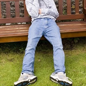 Depressed teenage boy on park bench