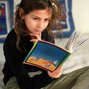 An 8-year old girl reading, France, Europe