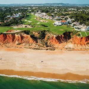 Aerial drone view of Praia de Vale do Lobo with magnificent golf courses overlooking the ocean in Algarve, Portugal, Europe