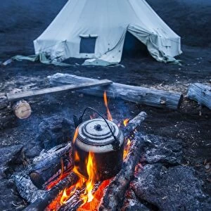 Boiling water pot over an open fire on a campsite and tipi on Tolbachik volcano, Kamchatka, Russia, Eurasia