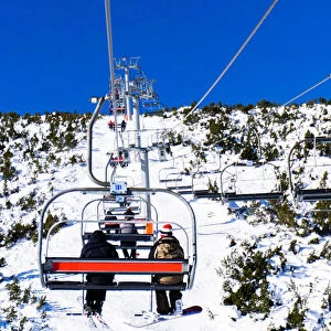 Borovets Ski Resort, a skier and snowboarder sit on Markudjik ski lift, Bulgaria, Europe