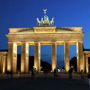 Puente de Brandenburgo iluminado por la noche en el Plazas del Pueblo alemán Puente de Brandenburgo iluminado por la noche en el Plazas del Pueblo alemán