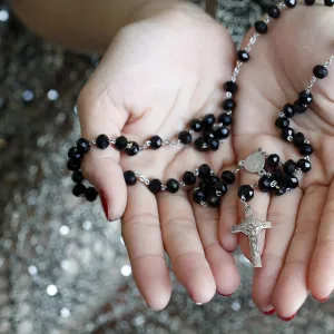 Catholic woman praying rosary beads and crucifix, Vietnam, Indochina, Southeast Asia