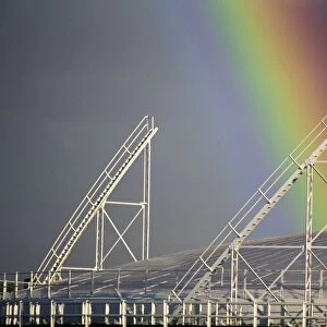 Close-up of the end of a rainbow over a gasometer at Richmond, near London