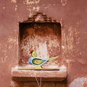 Decorative childs toy parrot in traditional wall niche