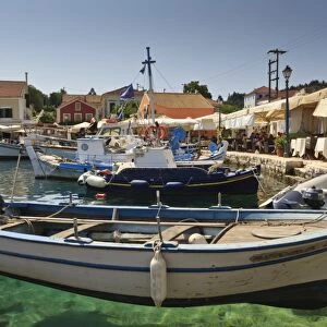 Harbourside with boats, cafes and clear green water, Fiskardo, Kefalonia (Cephalonia), Ionian Islands, Greece