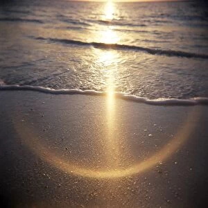 Image taken with a Holga medium format 120 film toy camera of sunlight reflecting on wet sand